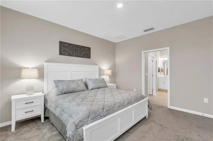 Bedroom with light colored carpet and ensuite bath