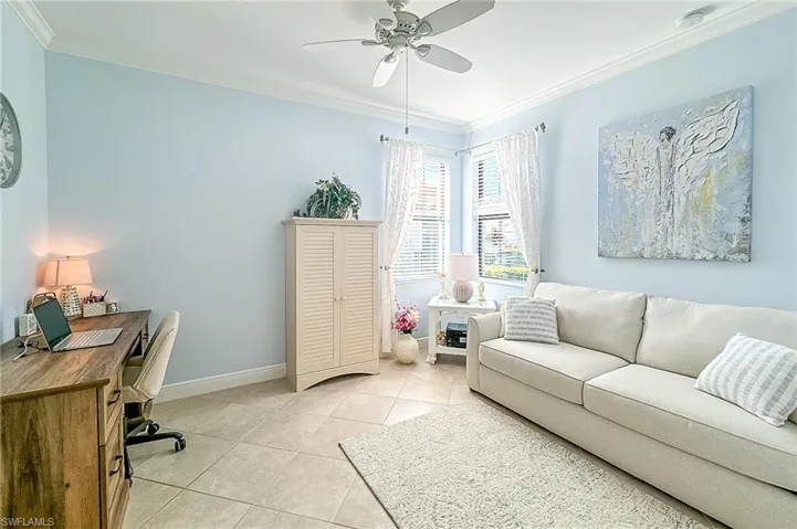 Tiled office featuring ornamental molding and ceiling fan