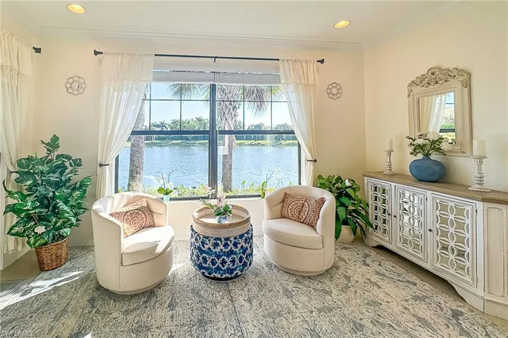 Living area with crown molding, plenty of natural light, and a water view