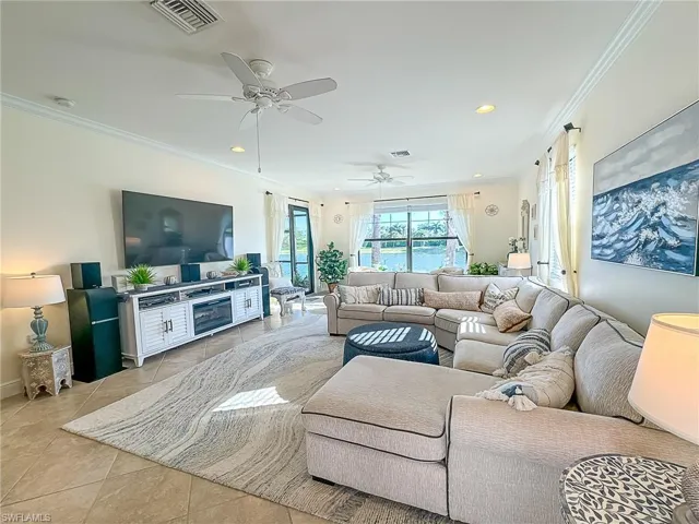 Tiled living room with ornamental molding and ceiling fan