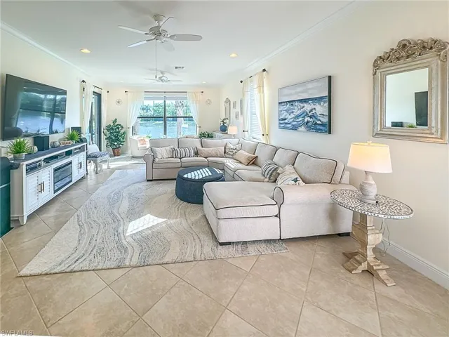 Tiled living room featuring ornamental molding and ceiling fan