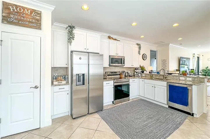 Kitchen featuring crown molding, stainless steel appliances, kitchen peninsula, and tasteful backsplash