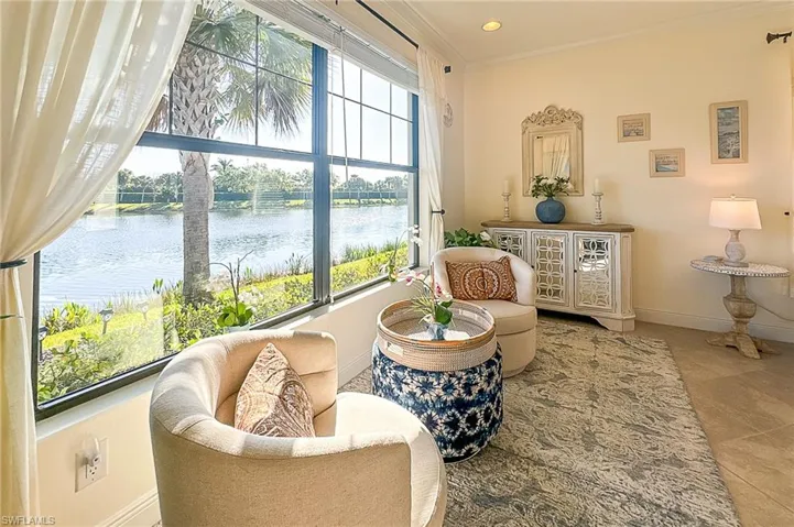 Sitting room featuring a water view, tile flooring, and crown molding