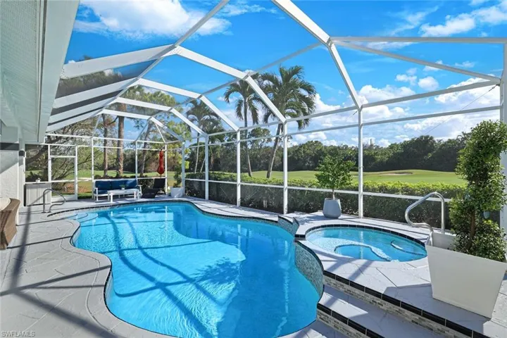 View of pool featuring an in ground hot tub, a patio area, and glass enclosure