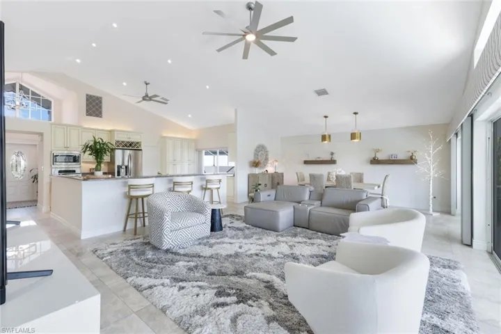 Tiled living room with high vaulted ceiling and ceiling fan