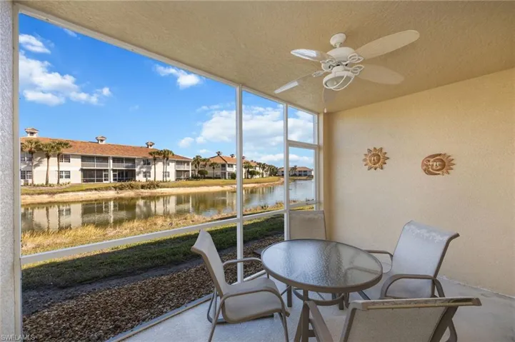 Sunroom / solarium featuring a ceiling fan, outdoor dining area, a water view, and a residential view