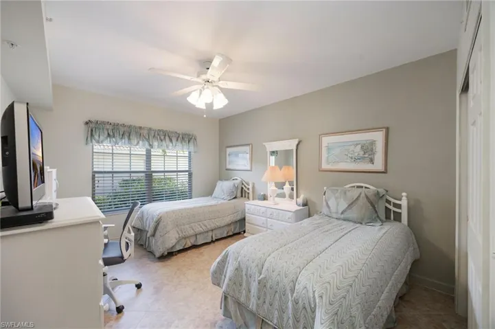 Bedroom featuring an office area, ceiling fan, and a closet