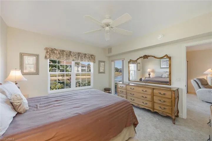 Bedroom with light colored carpet and a ceiling fan