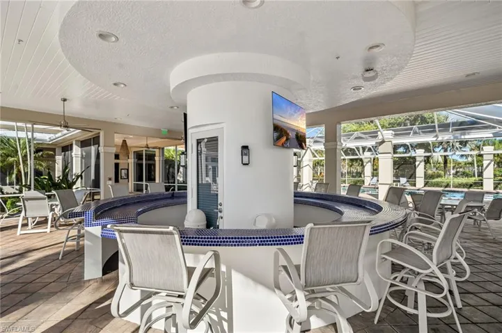 View of patio / terrace with a sunroom, a ceiling fan, a community pool, and a lanai