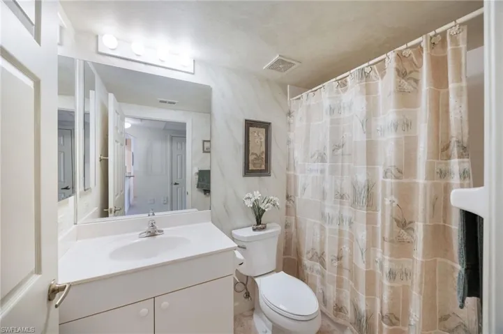 Bathroom with vanity and curtained shower