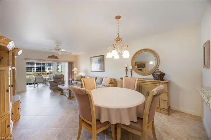 Dining space with ceiling fan, a chandelier, and light tile patterned floors
