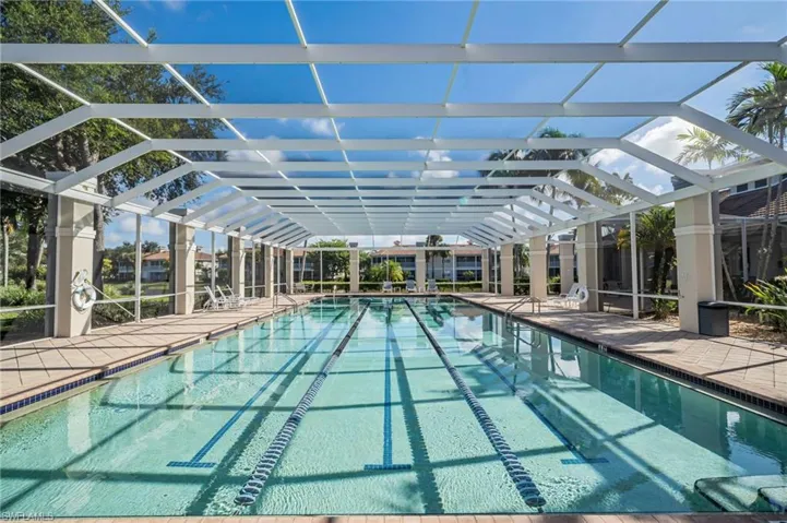 Community lap pool with a patio and a lanai