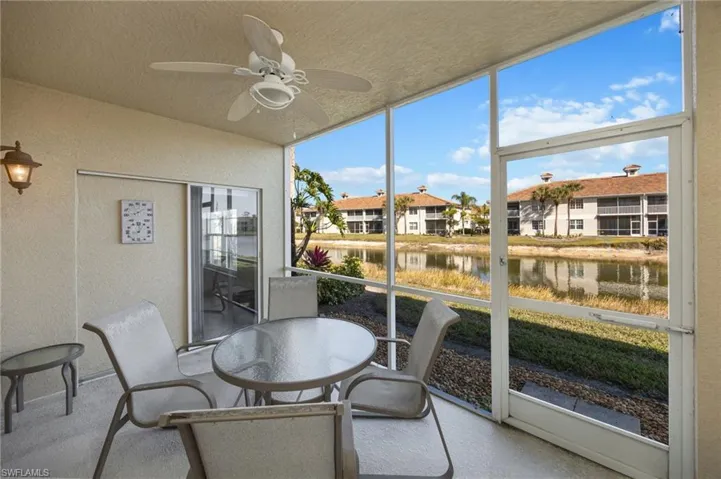 Sunroom with outdoor dining area, ceiling fan, and a water view