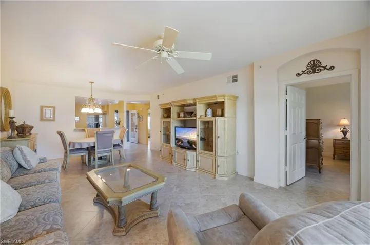Living area with ceiling fan, hanging lights, and light tile patterned flooring
