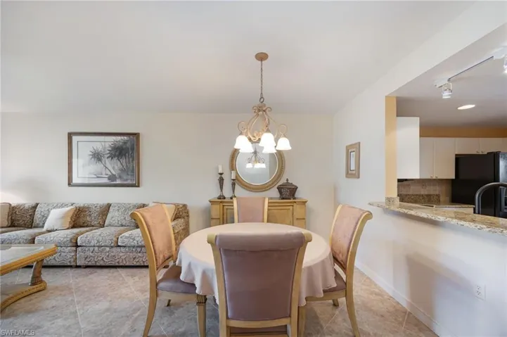 Dining room with suspended lighting and light tile patterned floors