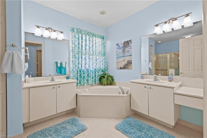 Huge primary bathroom with his and her sinks and a Roman tub