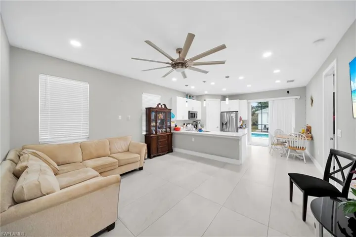 Living area with ceiling fan, recessed lighting, and light tile patterned flooring