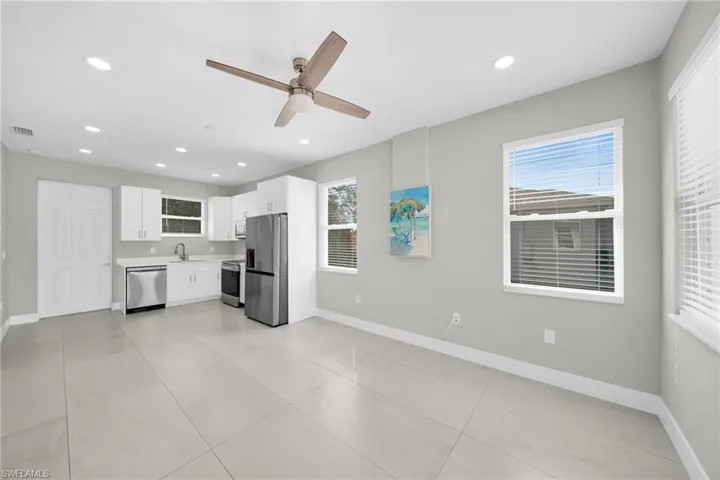 Kitchen featuring white cabinets, light countertops, a ceiling fan, stainless steel appliances, and healthy amount of natural light