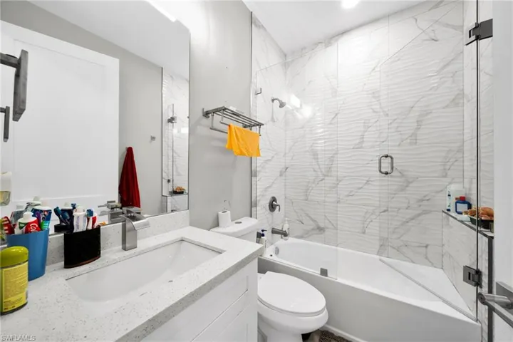 Full bath featuring vanity and combined bath / shower with glass door