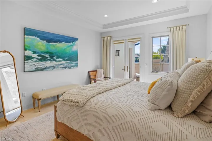 Bedroom with a tray ceiling, access to exterior, recessed lighting, and crown molding