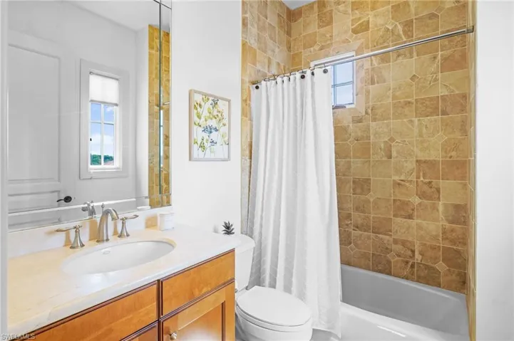 Bathroom featuring vanity and shower / bath combo with shower curtain