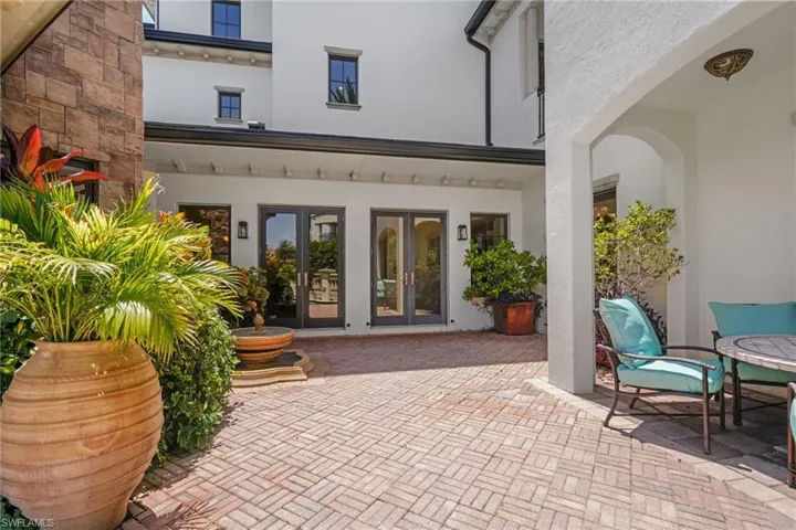 Rear view of property with french doors, stucco siding, and a patio area