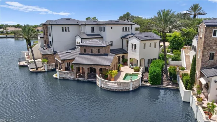 Back of house featuring a water view, stucco siding, and a patio