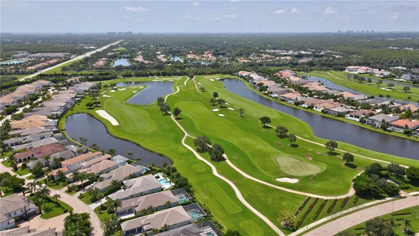 Aerial overview of property's location with a golf club, nearby suburban area, and a nearby body of water