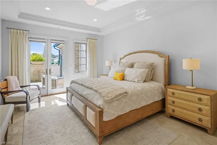 Bedroom featuring access to exterior, a tray ceiling, french doors, recessed lighting, and light tile patterned flooring