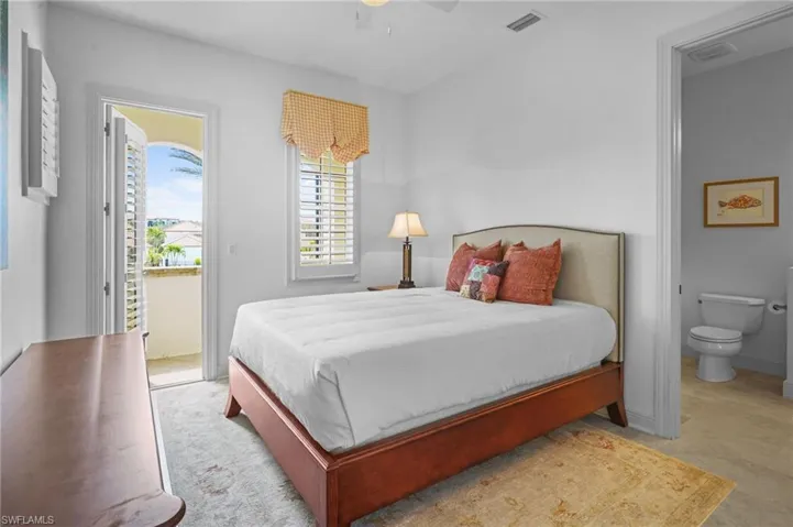 Bedroom featuring access to outside, ceiling fan, and ensuite bath