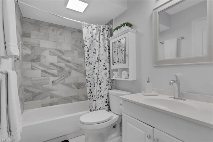 Full bathroom featuring a white vanity with integrated sink, framed mirror, and built-in medicine cabinet