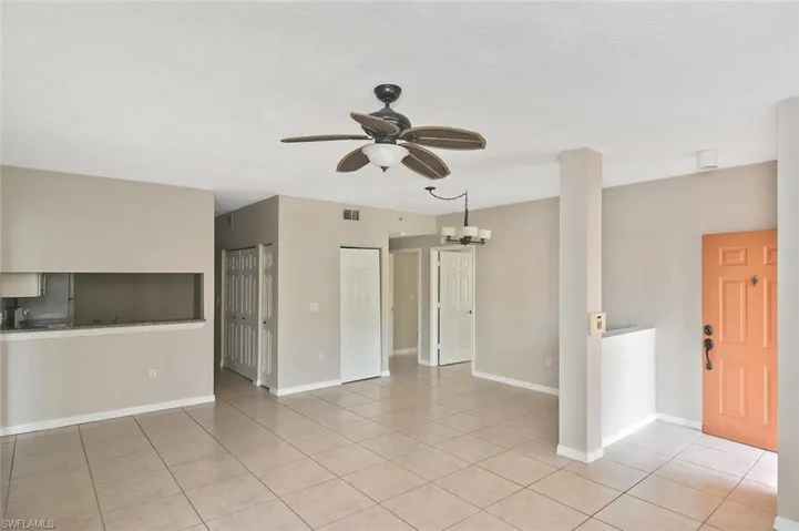 Unfurnished living room with a ceiling fan, suspended lighting, and light tile patterned floors
