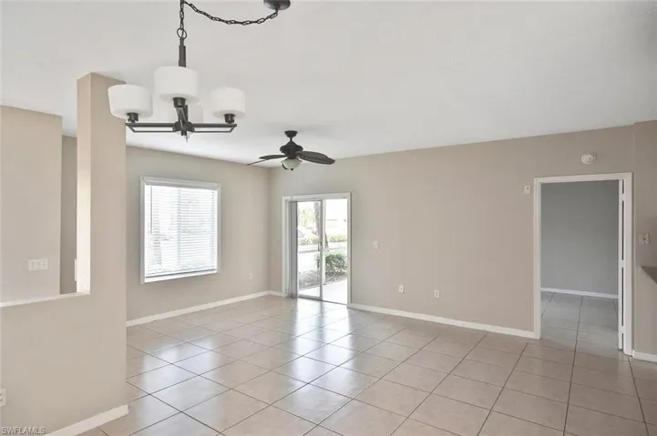 Spare room featuring ceiling fan, a chandelier, and light tile patterned floors