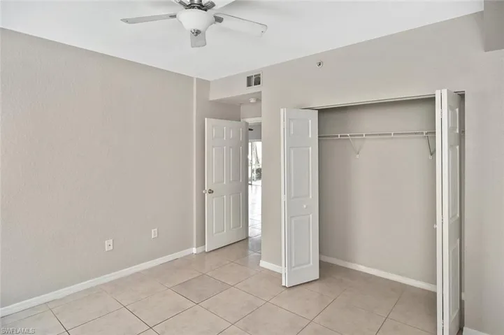 Unfurnished bedroom featuring a ceiling fan, a closet, and light tile patterned floors