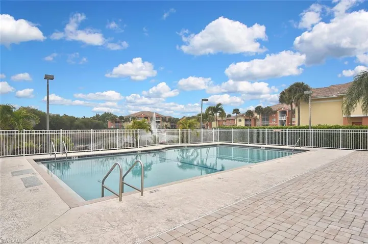 Community pool with a patio area and a residential view