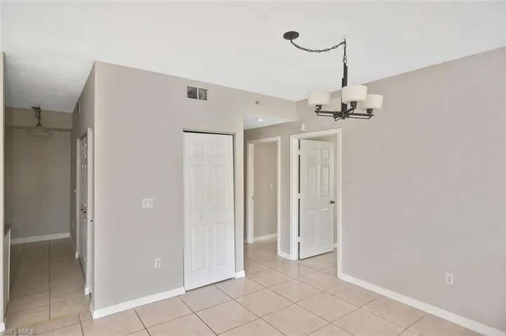 Unfurnished dining area with a chandelier and light tile patterned floors