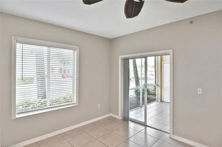 Empty room featuring light tile patterned flooring and ceiling fan