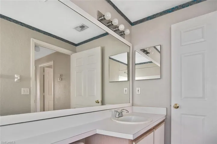 Bathroom featuring vanity and a textured wall