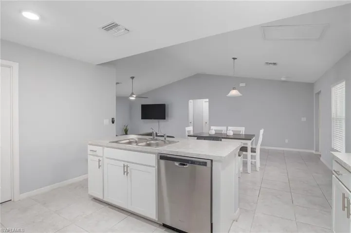 Kitchen featuring a sink, dishwasher, white cabinets, and visible vents