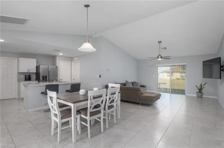 Dining room featuring recessed lighting, ceiling fan, visible vents, light tile patterned flooring, and high vaulted ceiling