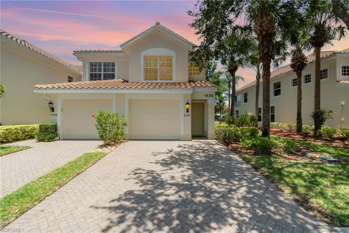Mediterranean / spanish house with stucco siding, decorative driveway, a tile roof, and an attached garage