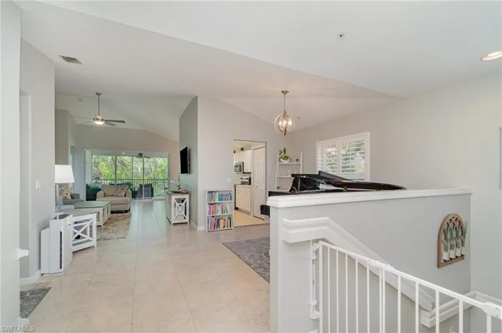 Hall featuring vaulted ceiling, baseboards, an upstairs landing, a chandelier, and recessed lighting