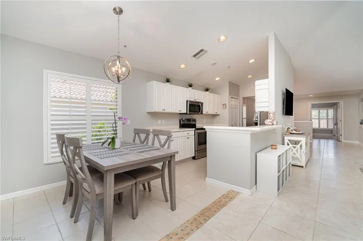 Dining room featuring a chandelier, baseboards, light tile patterned flooring, and recessed lighting