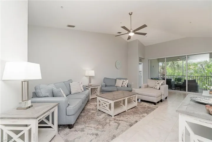 Living room featuring a ceiling fan and high vaulted ceiling