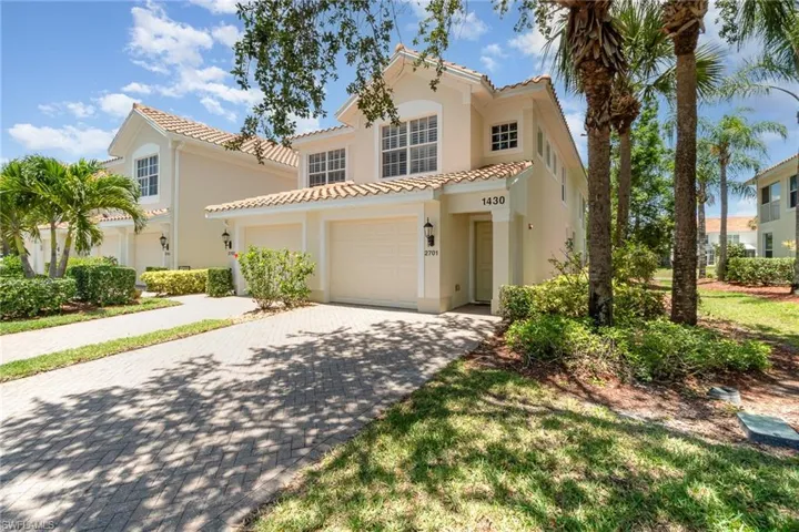 Mediterranean / spanish house with stucco siding, a tile roof, driveway, and a garage