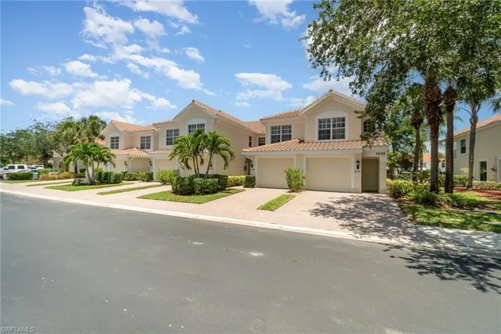 Mediterranean / spanish-style home with a garage, stucco siding, a tile roof, and decorative driveway