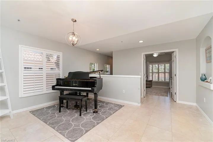 Living area with a chandelier, recessed lighting, light tile patterned floors, and baseboards