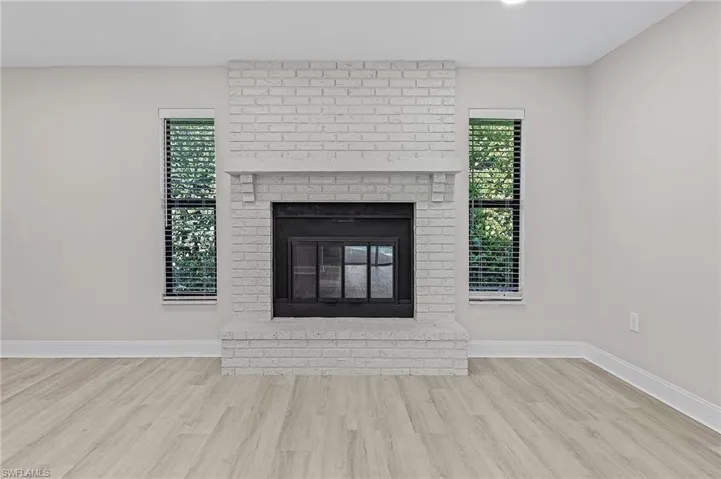Details featuring hardwood / wood-style flooring and a brick fireplace