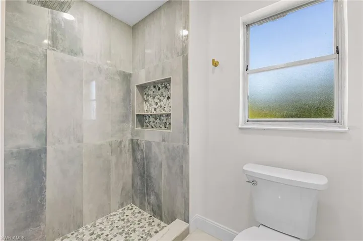 Bathroom with toilet and a tile shower