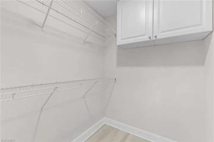Spacious closet with light hardwood / wood-style floors